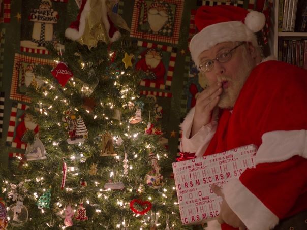 John as Santa Claus caught leaving gifts under the Christmas tree
