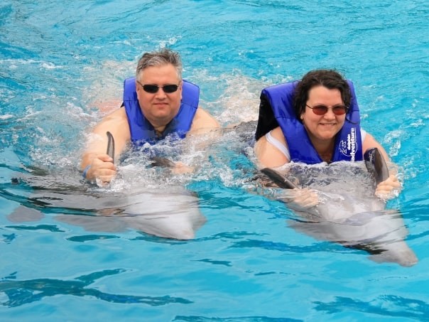 John and his wife Tressa swimming with dolphins